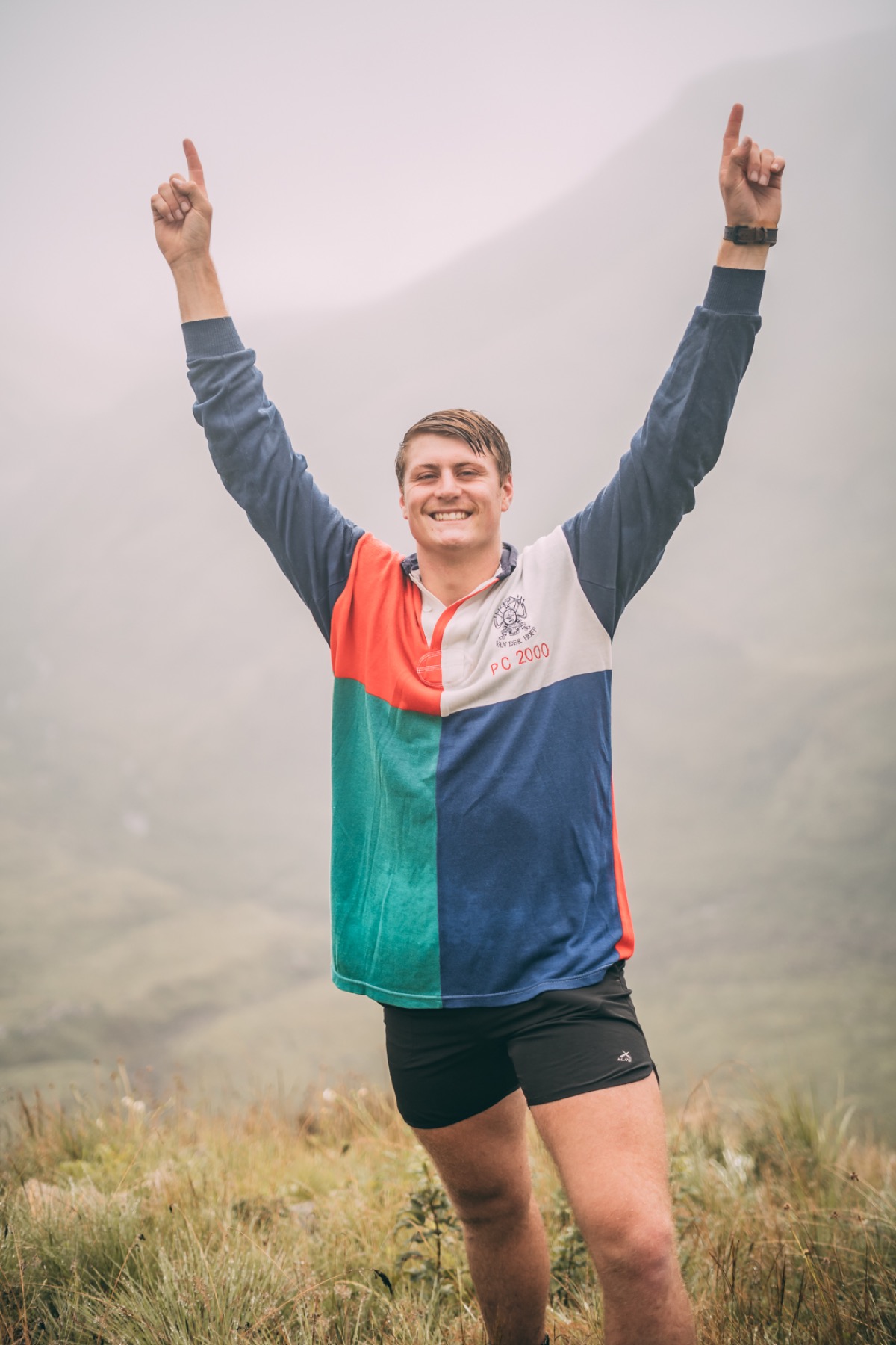 Maree in die berge met arms omhoog